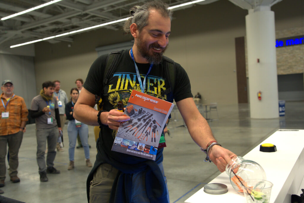 A hopeful winner smiles as they turn in their ticket to participate in the human slot machine at the ACCT Booth in the Exhibit Hall at the 2025 conference and exposition.