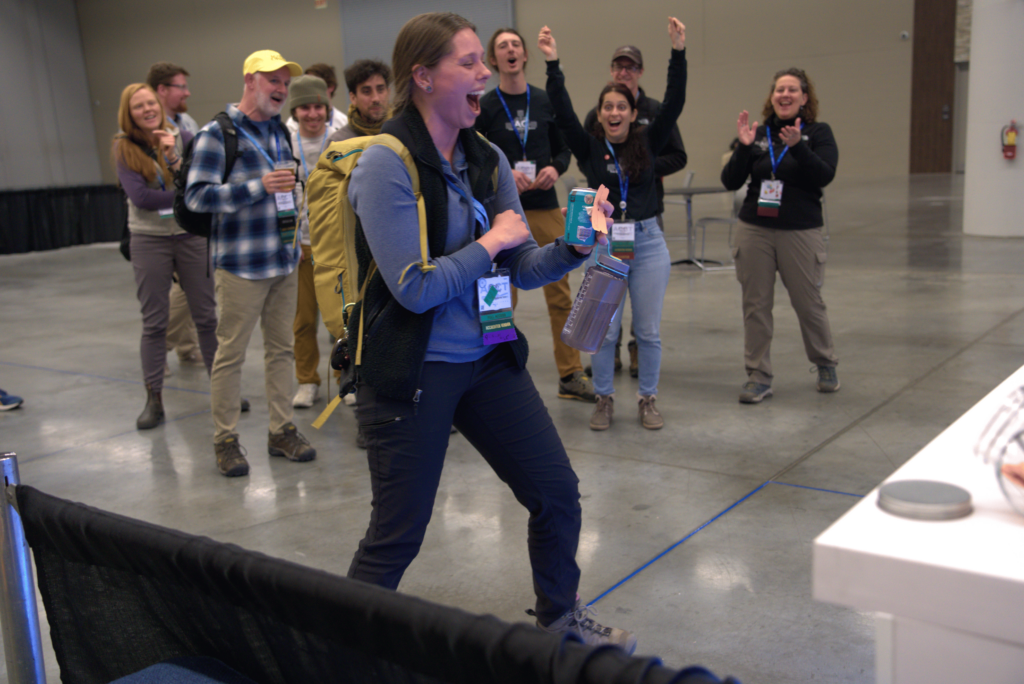 A winner of the human slot machine cheers with the crowd behind her after trying her luck at the ACCT Booth in the Exhibit Hall at the 2025 conference and exposition.