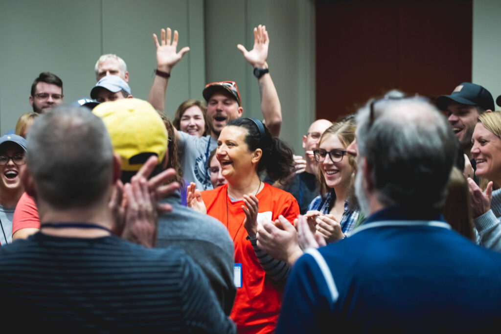 A group of session attendees clap and cheer following the conclusion of a session activity.