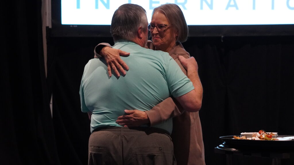 John Winter hugs his wife after winning the Critical Link Award during the Awards Ceremony at the 2025 ACCT conference and exposition.