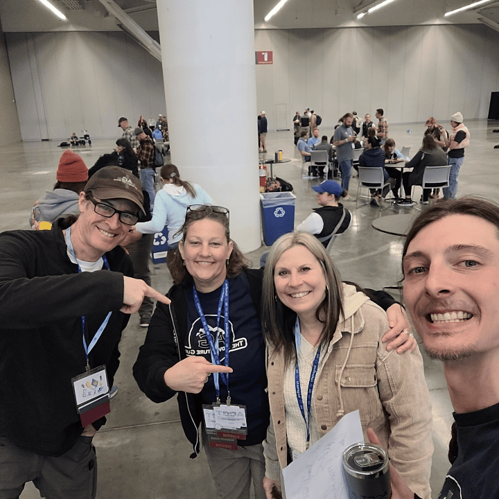 Three members of the Harnessing ACCT team Big Bubbles, No Troubles pose with an accredited member in the Exhibit Hall during the 2025 conference and exposition.