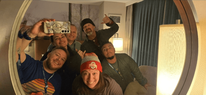 Six members of the Harnessing ACCT team Buckeye Treehuggers smile in a hotel mirror during the 2025 conference and exposition.