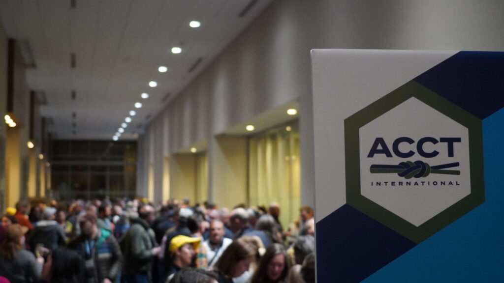 The ACCT International logo is seen on the right side of the image while a crowd of people are seen in the background during the Cocktail Reception before the Awards Ceremony during the 2025 conference and exposition.