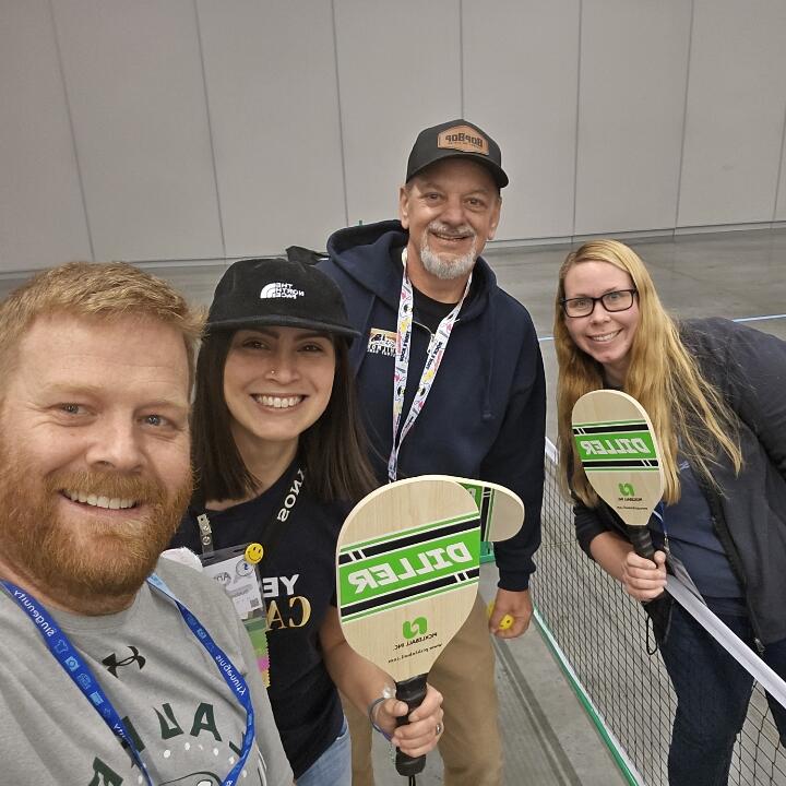 Four members of the Harnessing ACCT team Red Feather Flyers smile after playing a game of pickleball together in the Exhibit Hall thanks to Cuyahoga Community College during the 2025 conference and exposition.