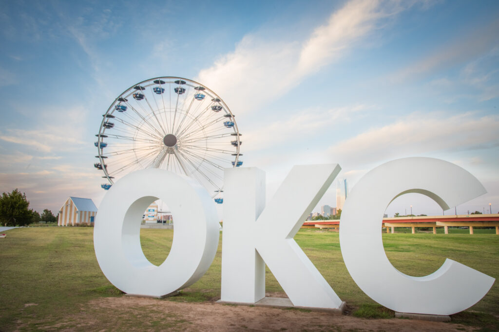 The letters "OKC" are seen in front of the Wheeler District Ferris Wheel in Oklahoma City, Oklahoma, USA.