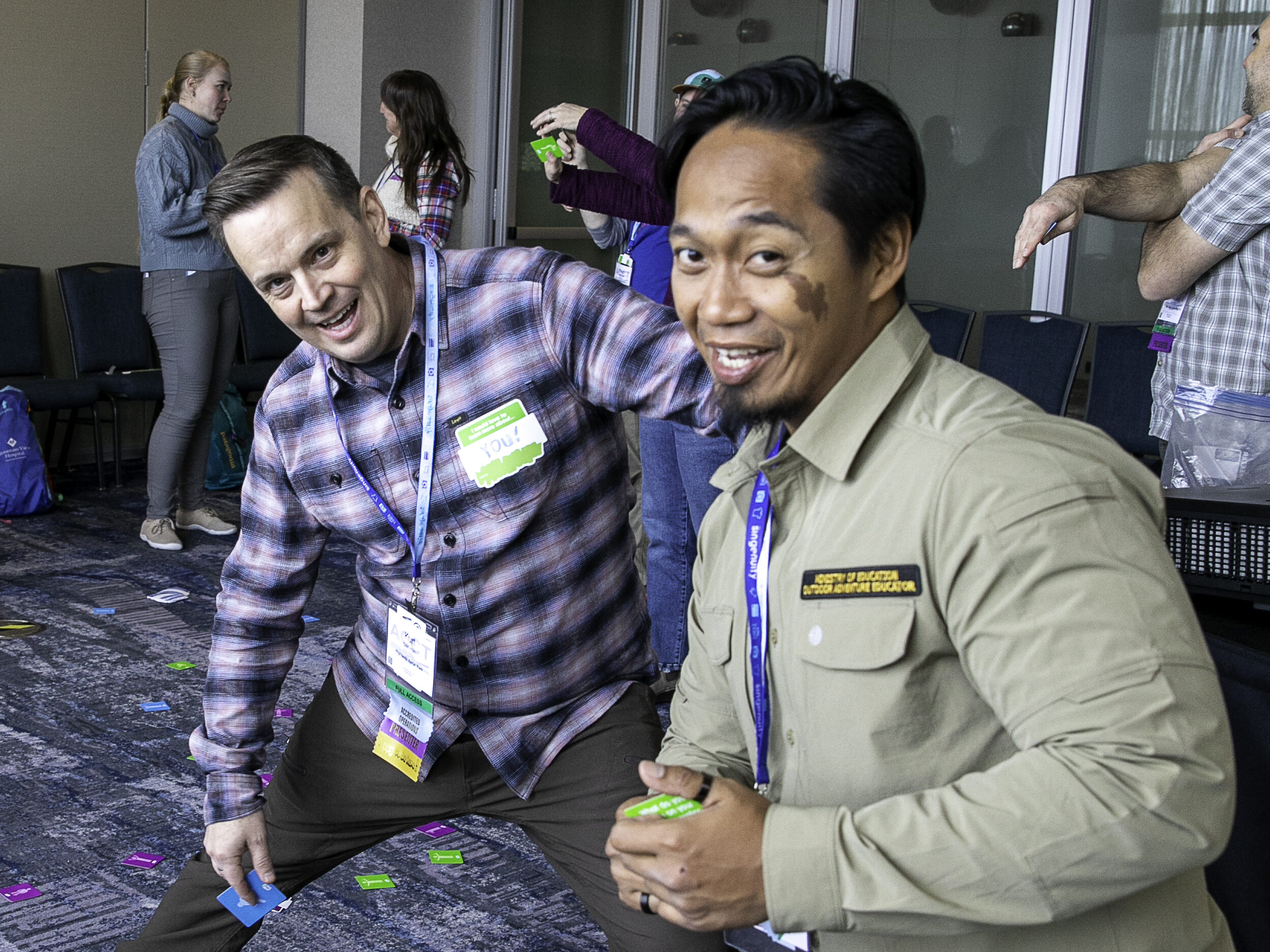 Two people attempting to complete a challenge during an activity smile at the camera during the 2025 ACCT conference and exposition.