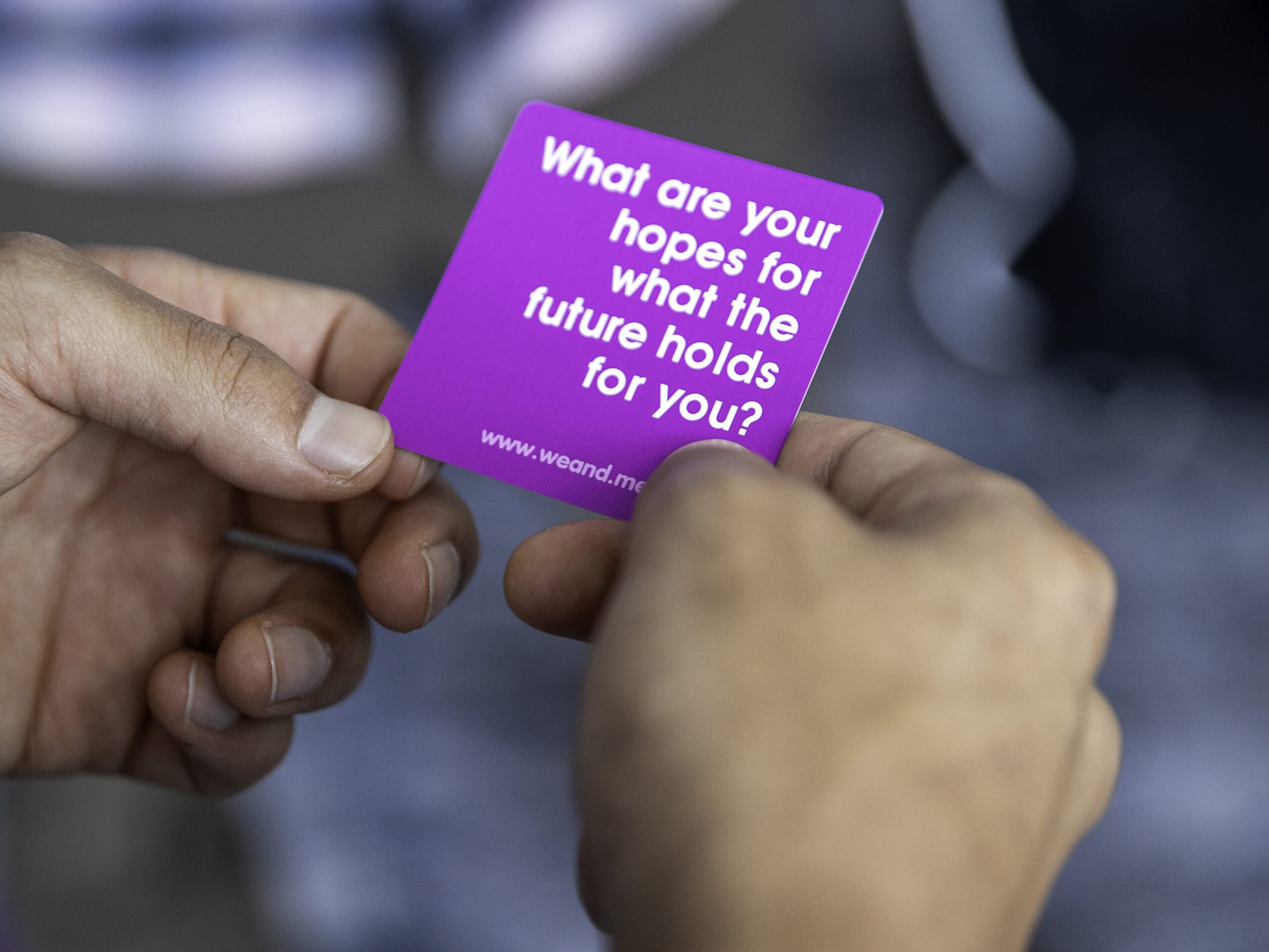 Hands hold the edges of a square purple card that reads "What are your hopes for what the future holds for you?" in white text during the 2025 ACCT conference and exposition.