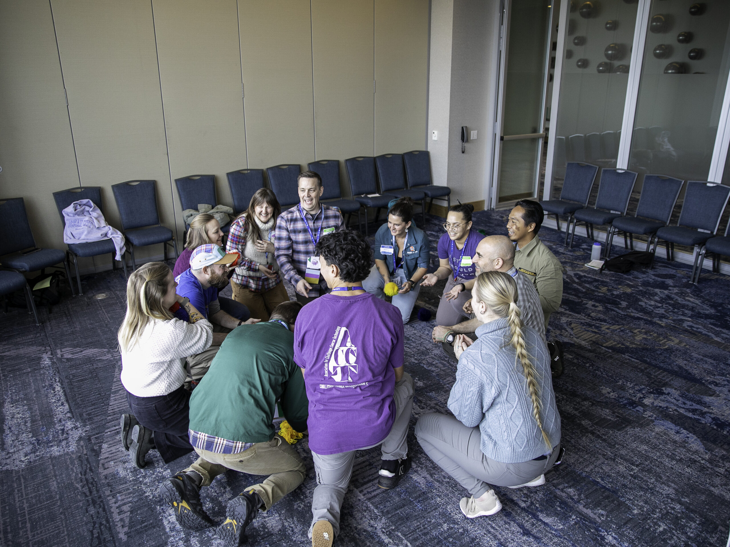 A group of session attendees laugh together while debriefing an activity during the 2025 ACCT conference and exposition.