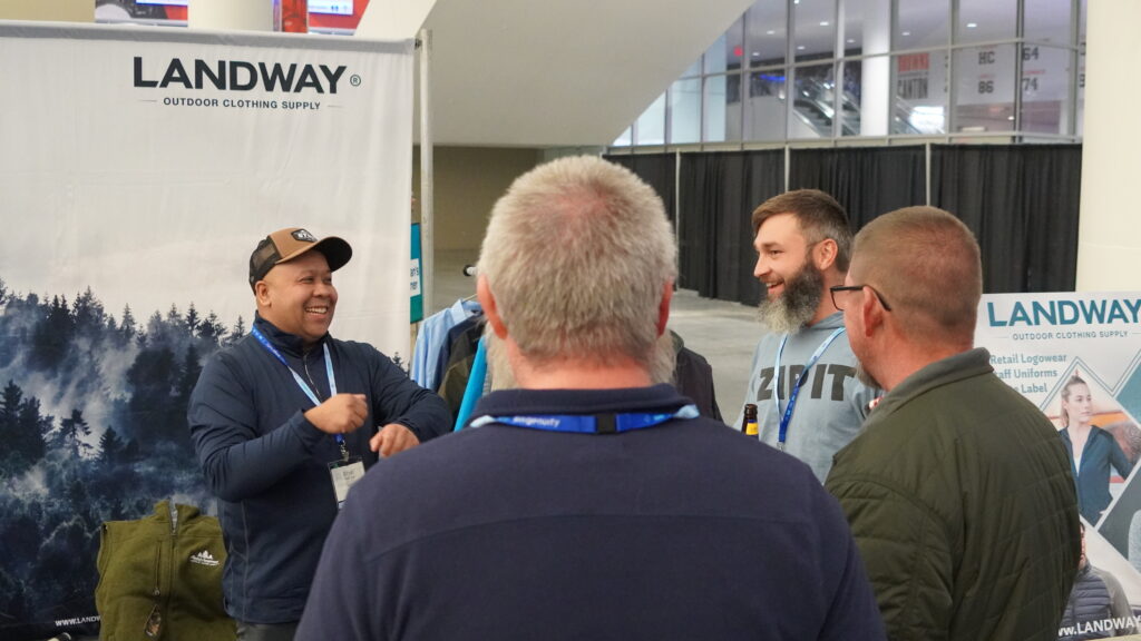 An exhibitor laughs with attendees while discussing their products in the Exhibit Hall at the 2025 ACCT conference and exposition.